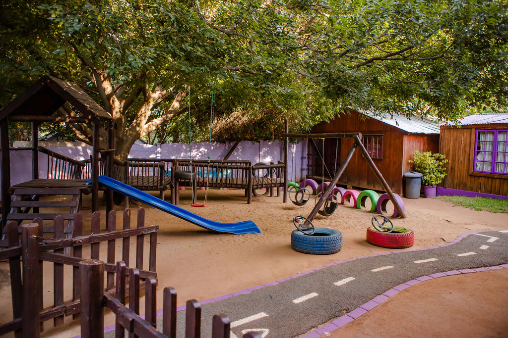 Larger outdoor adventure area with swings, slide and tyre play structures